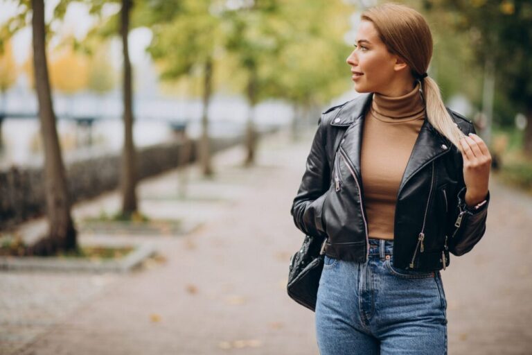 Femme portant un perfecto en cuir noir avec un jean et des bottines en ville.